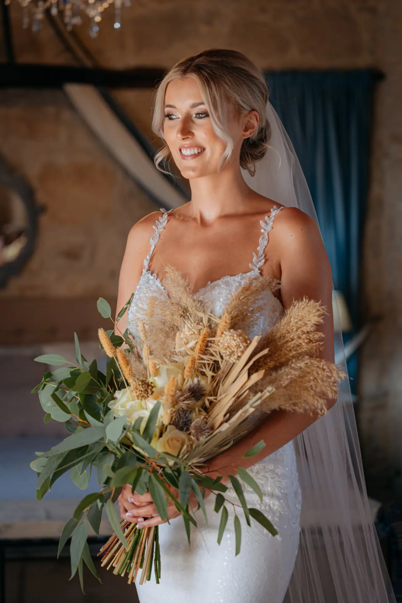 Abby smiling with a dried pampas and greenery bouquet at Liopetro