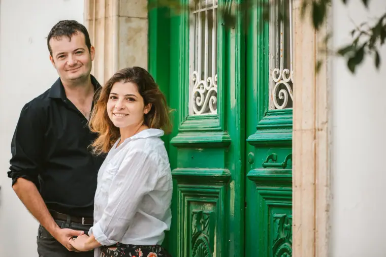 Smiling couple in front of a green wrought-iron door in Lefkara