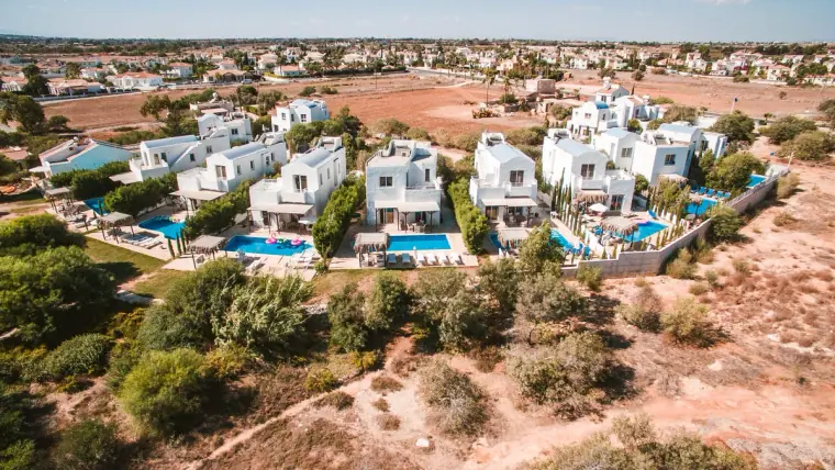 Aerial view of the white villas and pools of Thalassines Beach Villas, Ayia Napa