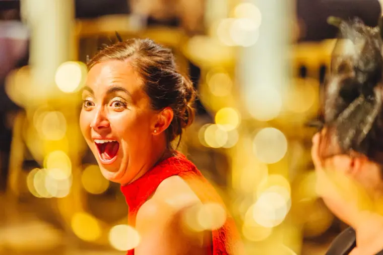 Guest in red with an open-mouthed expression of surprise