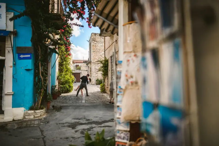 Narrow village lane with blue doors, bougainvillea and a lace display in Lefkara, Cyprus