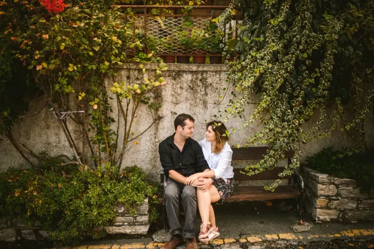 Couple sitting on a bench beneath ivy-covered walls in Lefkara