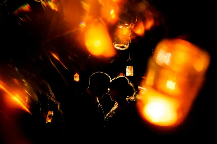 Silhouette of the couple kissing among glowing lanterns at night, Ayia Napa
