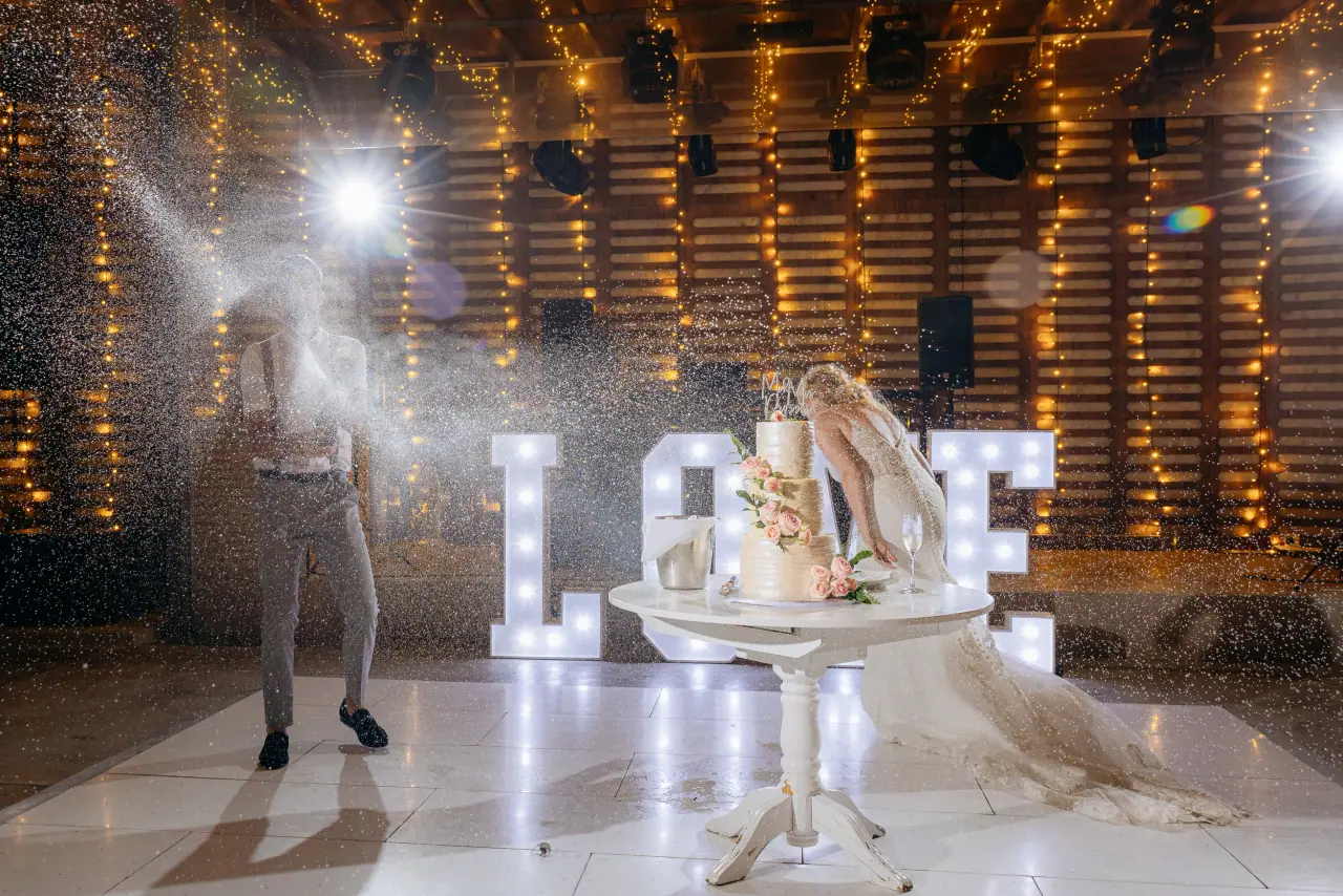 Wedding cake table before glowing LOVE letters as sparks fill the dancefloor at Alassos