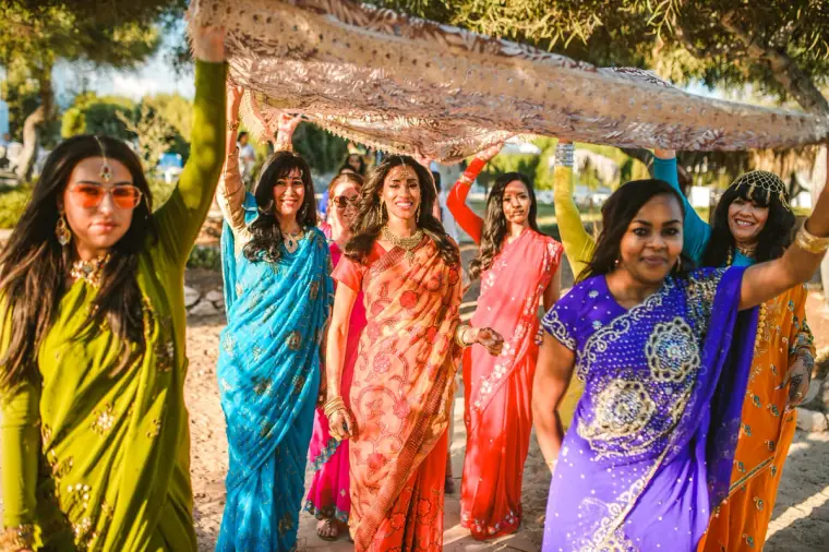 Bride's procession under a gold-edged canopy among pine trees, Thalassines Beach Villas