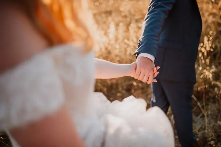 Close-up of the couple's joined hands, her lace sleeve in soft focus, Vasilias Nikoklis Inn