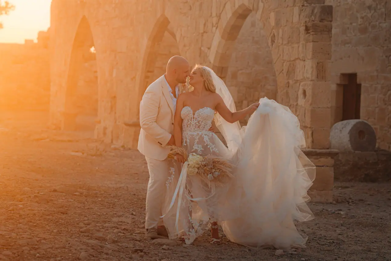 Jody and Simon dancing at golden hour among stone arches at Liopetro, Kouklia