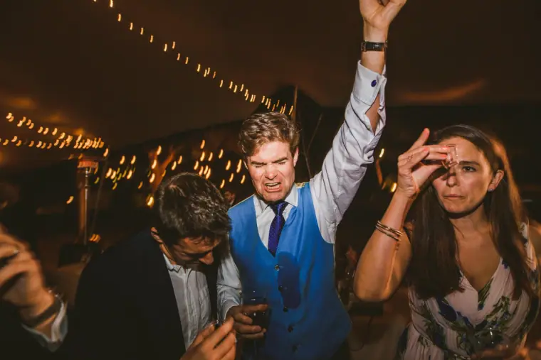 Guests dancing and cheering under fairy lights at Nermine and Chris's reception, Lexeko Estate
