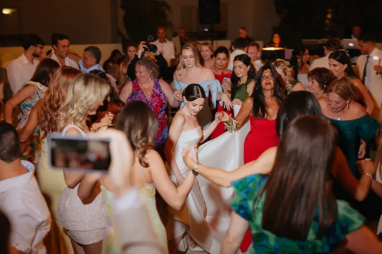 Bride dancing among a crowd of guests at the evening reception