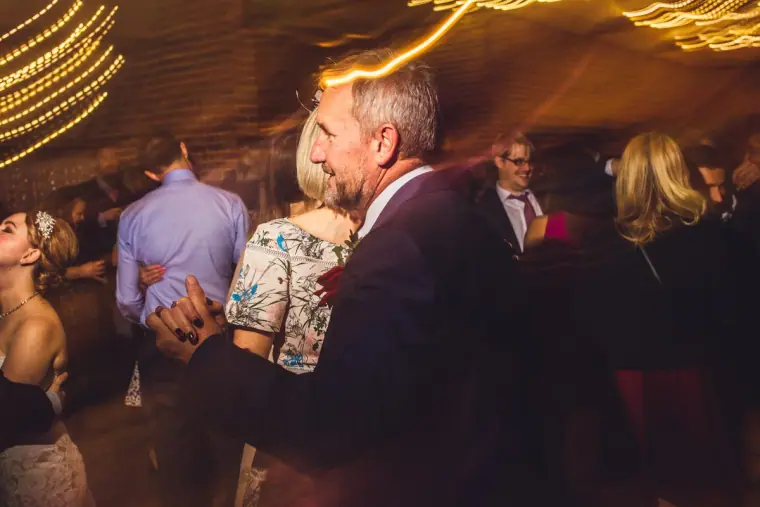 Guests dancing under swirling lights in the barn