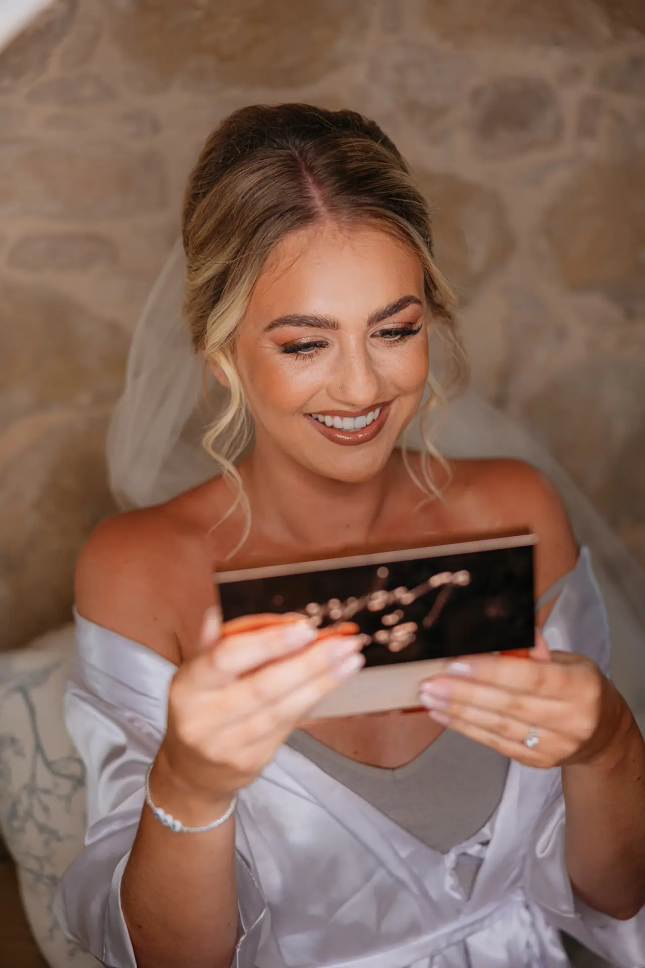 Megan smiling as she opens a gift box while getting ready at Liopetro