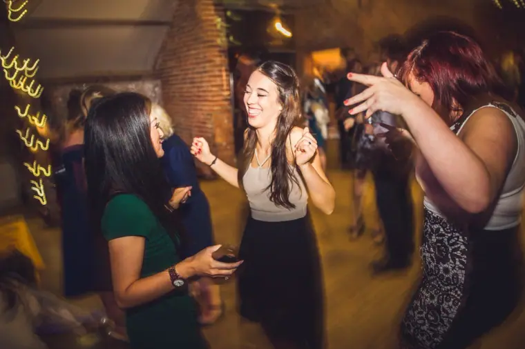 Guests dancing and singing along under fairy lights