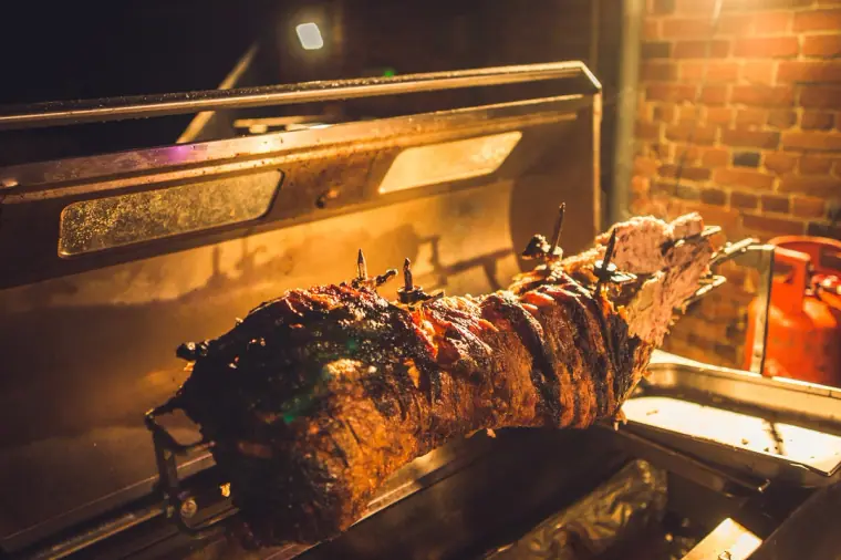 Hog roast turning on a spit in the evening