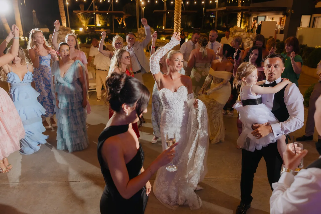 Bride dancing in a crowd of guests in summer dresses