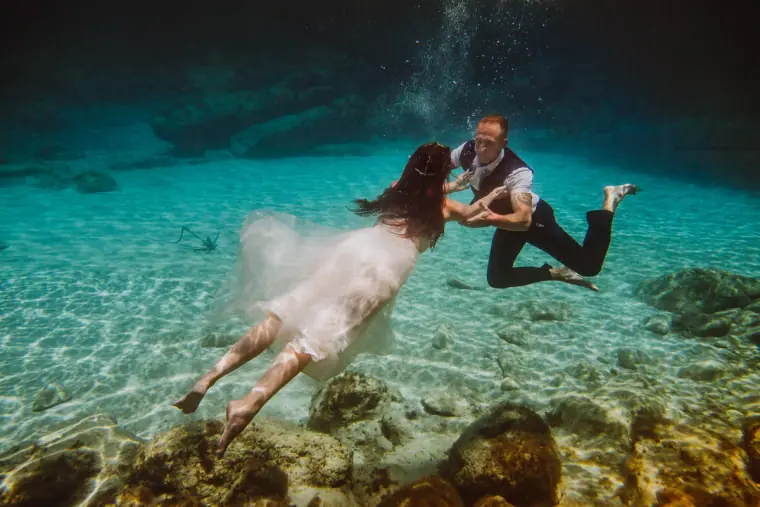 Sarah and Martin swimming underwater over rocks in clear turquoise sea, Ayia Napa