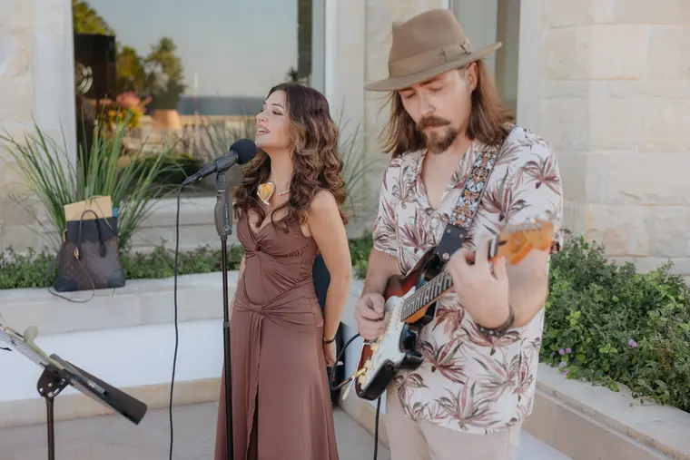 Singer and guitarist in a floral shirt performing during the cocktail hour