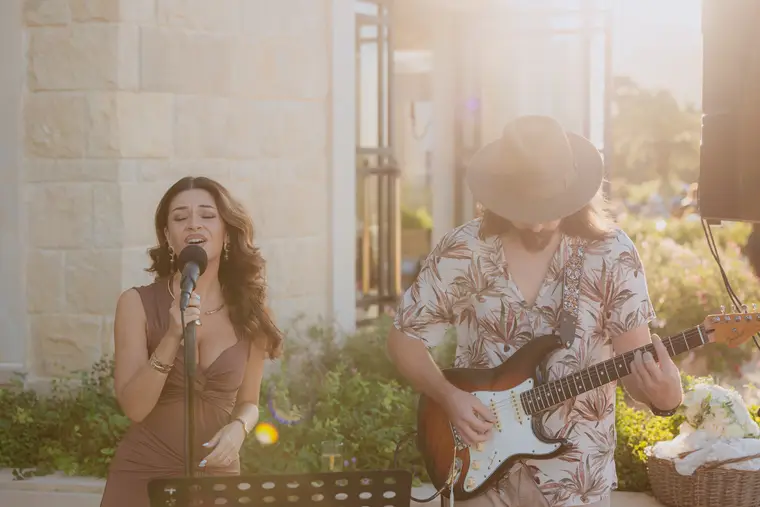 Singer at the microphone and guitarist playing in the evening sunshine