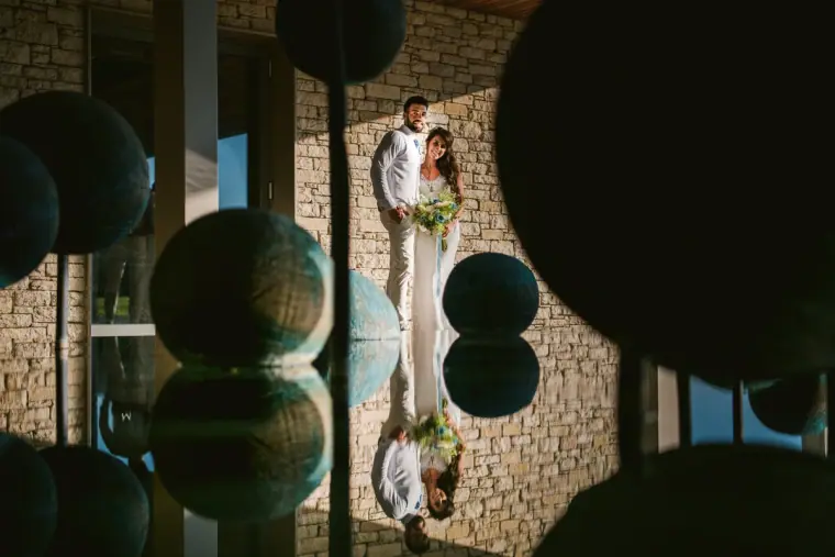 Couple reflected in a mirror wall among dark round lanterns