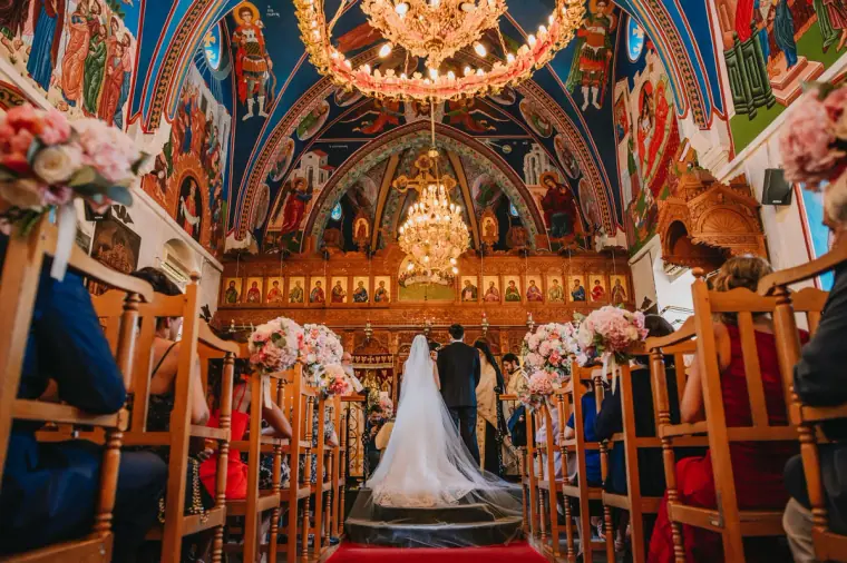 Bride and groom at the altar of an ornately painted Orthodox church, Limassol