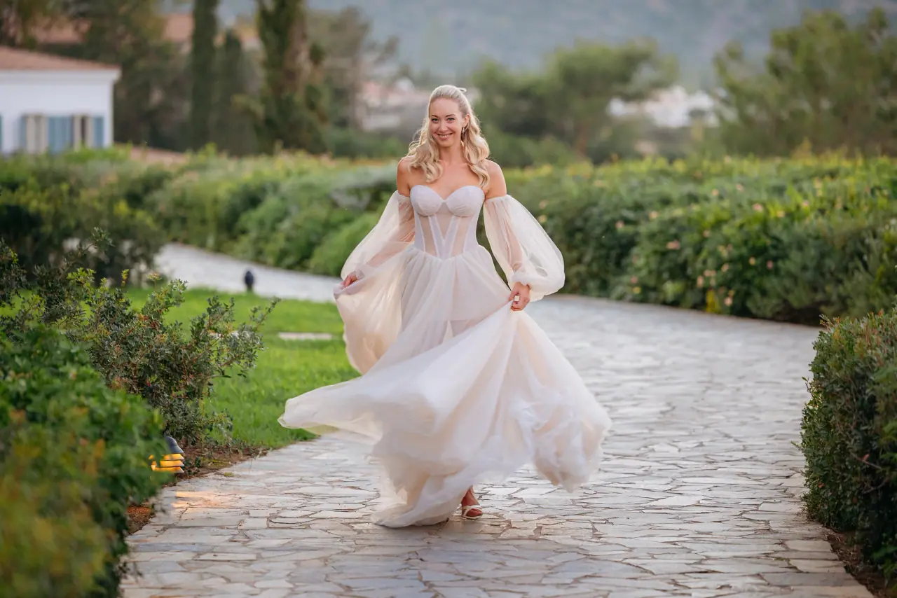 Jade twirling her dress along a cobbled garden path at Anassa, Paphos