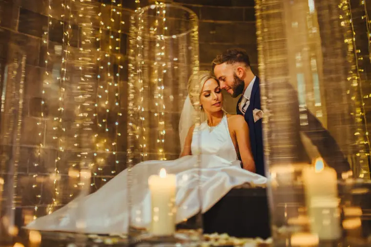 Couple framed by glass candle holders and strings of fairy lights, Edinburgh