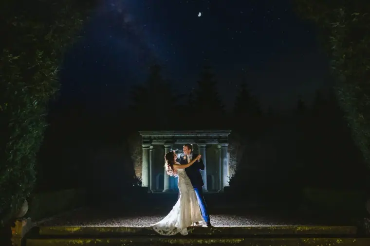 Elina and Iain dancing before a lit stone folly under a starry sky at Wotton House, Surrey