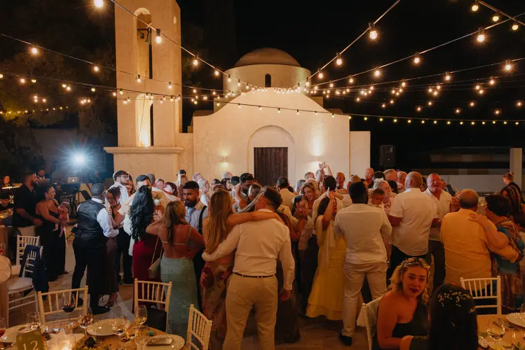 Guests dancing beside Anassa's floodlit chapel at night