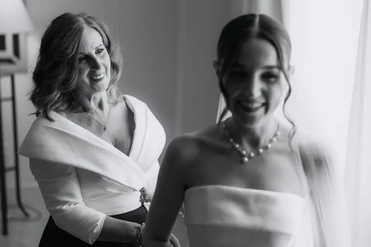 Black-and-white photo of Poppy sharing a smile with an older woman while getting ready