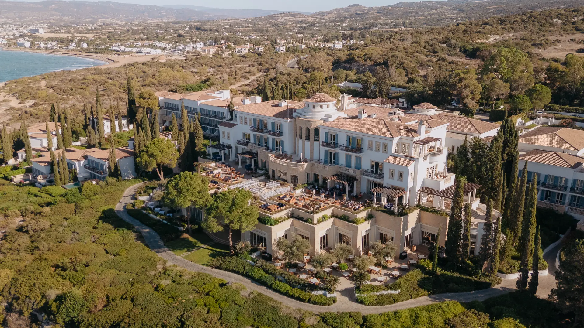 Aerial view of Anassa among gardens and cypress trees above Chrysochous Bay