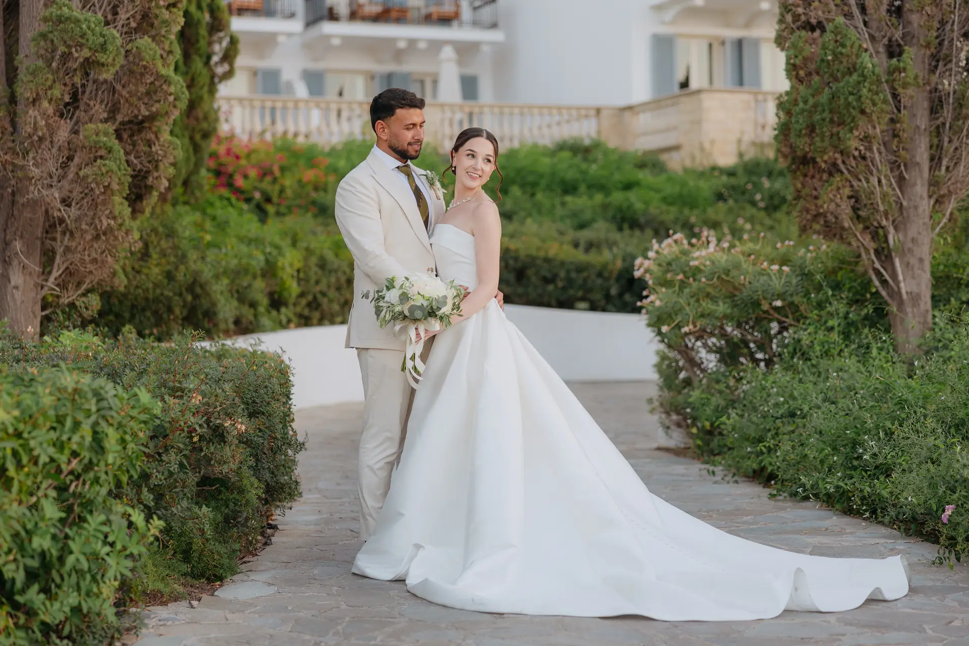 Poppy and Andrew in Anassa's gardens, her long train spread across the path